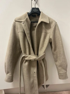 Kappa - 🤎Superfin Beige kappa från Vero Moda 🤎Storlek S 🤎Medellång 🤎Silver knappar 🤎Med bälte  🤎Är knappast använd