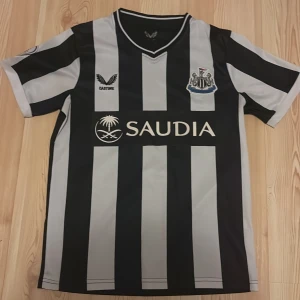 Newcastle fotbollströja - Jag säljer en Newcastle premier leauge tröja som är i mycket bra skick (nästan ny). Tröjan är randig med svartvita färger och är för alla. Pris kan diskuteras