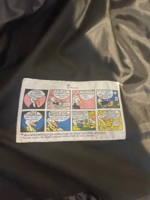 Svart pufferväst från Moncler - Säljer en svart pufferväst från Moncler med glansig finish och ståkrage. Västen har Moncler-logga på bröstet och dragkedja framtill. Perfekt att slänga över en hoodie för en cool look. Materialet är syntet och dun, vilket gör den både lätt och varm.