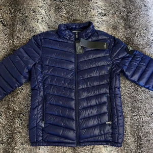 Blå pufferjacka från Stone Island - Snygg marinblå pufferjacka i Storlek S från Stone Island, originella och svart vita badgen medföljer! Utmärkt skick 10/10 och är perfekt för skolstarten inann höstterminen 🍂  Priset kan diskuteras! Vid snabba affär och bundle köp🤭 Frågor om Mer bilder eller Passform? Kontakta mig🤝