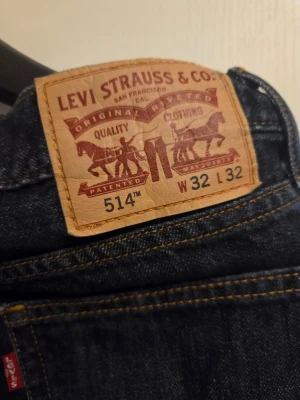 Levi's 514 mörkblå jeans W32 L32 - Säljer ett par Levi's 514 jeans i mörkblå tvätt med klassisk femficksdesign och raka ben. Jeansen har snygga kontrastsömmar och är tillverkade i slitstarkt denim. Perfekt för dig som gillar en tidlös och clean look.