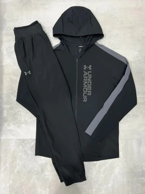 UNDER ARMOUR - STORM TRACKSUIT - Under Armour – Storm Tracksuit • Jacka och byxa i matchande färg • Storlekar från XS till 2XL • Går också att få den på sneaks,se