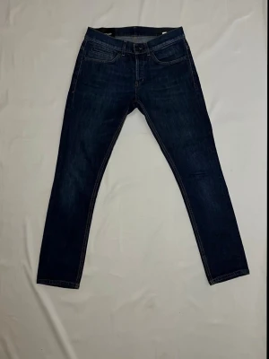 DONDUP JEANS - George - Hej! Säljer ett par riktigt snygga Dondup jeans i en mörkblå färg. Storlek 30. Modellen är George, en väldigt populär passform som sitter riktigt bra och är väldigt stilrent. Jeansen är i bra skick.  Hör gärna av er om ni har frågor! 