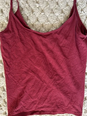 Vinröd linnetopp från Gina Tricot - Säljer en enkel och snygg vinröd linnetopp från Gina Tricot, basically basics-kollektionen. Toppen har smala axelband och är tillverkad i mjuk bomull. Perfekt att styla med jeans eller shorts för en chill look.