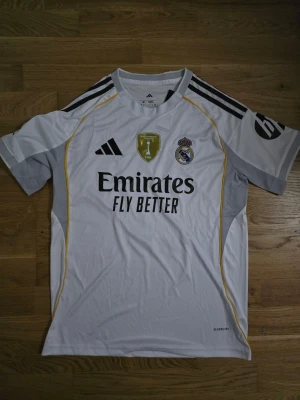 Real Madrid hemmatröja champions league 25/26 - Helt ny real madrid hemmatröja från nuvarande champions league säsong 25/26. Med Mbappe på ryggen och i storlek M.
