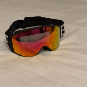 EQPE skidglasögon med spegelglas - Säljer mina snygga eqpe skidglasögon som jag aldrig har använt , jag köpte dem via Plick, men fick ett par i tidig julklapp så visade sig att jag ej behövde dem. Fint skick på dem annars. Någon små repa på utsidan men inget som på påverkar synen. 