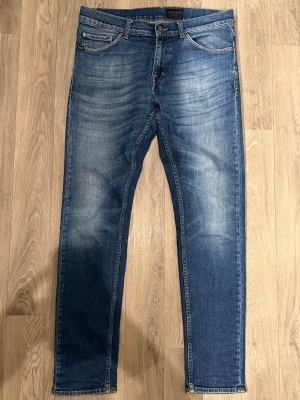Tiger of Sweden Evolve Jeans Blå W31 L32  - Blåa Tiger of Sweden Evolve Jeans i fint skick med sjuk tvätt i storlek W31/L32. Mått - Midja: 42cm, Benlängd: 102cm. Modellen är 185cm & 63kg. Hör av dig vid funderingar!🤩