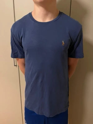 Blå Ralph lauren T-shirt - Snygg blå Ralph Lauren T-shirt.                                    Storlek M.                                                                          Mycket bra skick.                                                           Nypris=1000    Vårt pris= 349