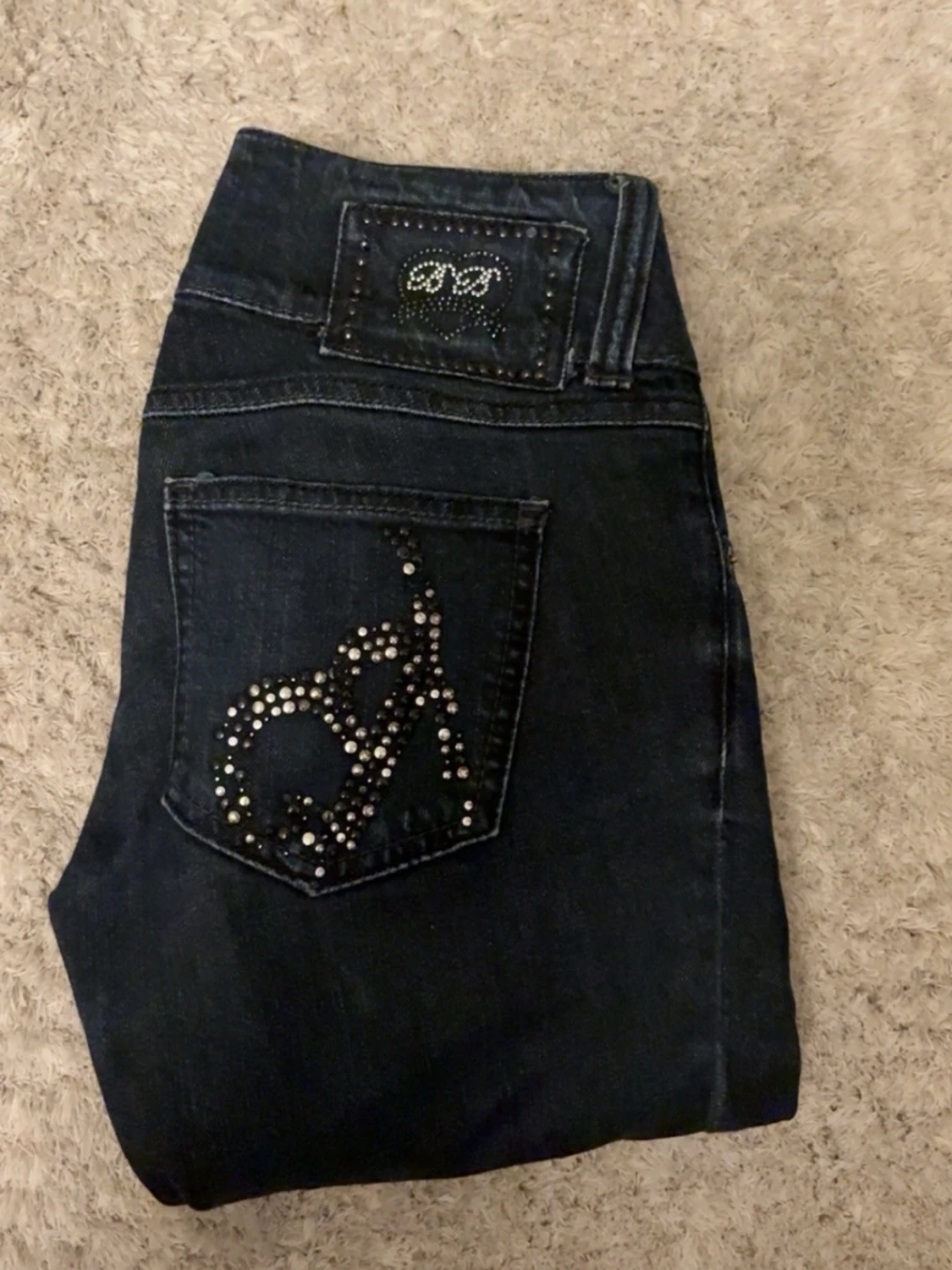 Mörkblå jeans med nitar på fickor