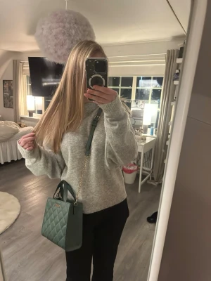 Grön quiltad handväska från Guess - Säljer en snygg grön handväska från Guess med quiltad design och guldfärgade detaljer. Väskan har både handtag och axelrem i kedja, samt ett rymligt fack med innerficka. Perfekt storlek för det viktigaste och ger en trendig touch till din outfit. Perfekt både till vardag och fest.🤍🤍