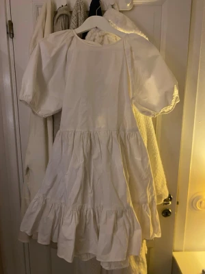 Rosett-puff klänning från NELLY🤍 - Säljer denna suuuupersöta klänningen med puffärmar och volangkant. Klänningen har öppen rygg med två gulliga rosetter som man knyter ihop och rund halsringning. Tillverkad i ett bomullstyg som känns luftigt och perfekt för varma dagar, student eller resa!✨            Från Nelly X Glamorous kollektion (endast använd 1-2 ggr)🙌