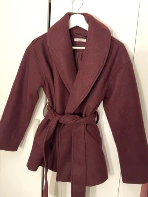 Vinröd kappa - Fin vinröd kappa från Gina tricot. Köpte i höstas men har bara kommit till användning en gång. Den har knapp för att stånga och band att knyta runt midjan, på sidan är det fickor. Storleken är xxs men jag brukar ha xs/s. Skriv gärna för fler frågor, prisförslag, bilder mm.