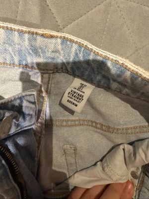Ljusblå vintage straight jeans &Denim - Säljer ett par ljusblå vintage straight jeans från &Denim. Modellen är high waist med klassisk femficksdesign och raka ben. Jeansen har en snygg tvättad look och är tillverkade i slitstarkt bomullsdenim. Perfekta för en avslappnad och trendig stil.