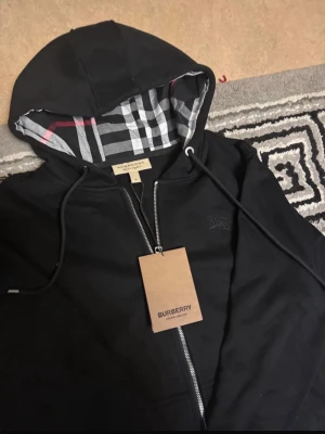 Burberry zip up - Säljer denna sköna och snygga tröjan som passar för både vinter och sommaren. Aldrig använd förr och känns otrolig när den används då man skiner av själv säkerhet. Den passar för både L och M