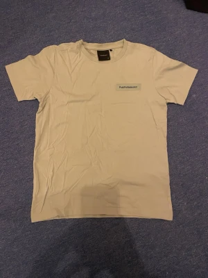 Ljus grön t-shirt från Peak Performance - Snygg ljus grön t-shirt från Peak Performance med klassisk logga på bröstet. T-shirten har rund halsringning och korta ärmar. Tillverkad i mjuk bomull som känns skön mot huden. Enkel och stilren design som funkar till det mesta.