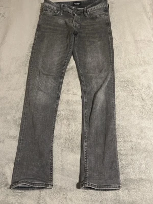 Jack & Jones 29/32 slimfit - Säljer ett par gråa slim fit jeans från Jack & Jones, modell Slim/Glenn. Jeansen har klassisk femficksdesign, normal midja och raka ben. Materialet är mjukt denim i bomull med lite stretch för extra komfort. Priset är inte hugget i sten.