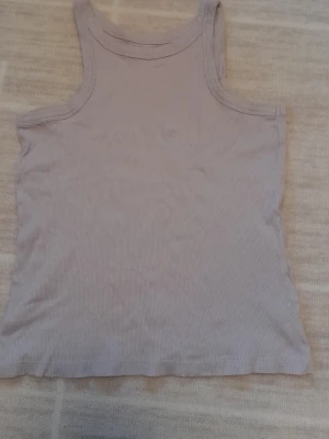 Ljuslila ribbad linnetopp  - Säljer en ljuslila ribbad linnetopp från 157 i storlek S. Toppen är ärmlös med klassisk rund halsringning och är gjord i 100% bomull. Perfekt till sommaren och enkel att matcha med olika stilar. !!endast swish +frakt!!