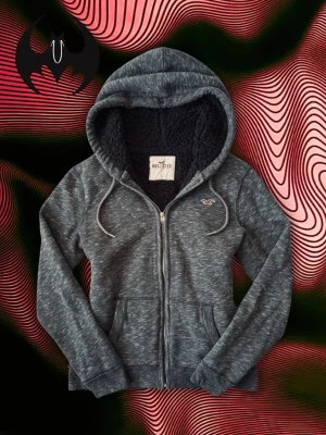 Mörkgrå Hollister Zip Hoodie  - Mörkgrå fodrad zip hoodie från Hollister | Pris kan diskuteras | Mycket bra skick | Size S/M | Längd: 65cm Armlängd: 68cm Axelbredd: 44cm | Model 162 cm, 60 kg OBS! Modellens längd påverkar inte hoodiens mått!