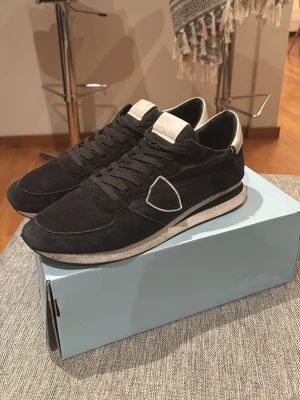 Philippe Model svarta sneakers strl 45 - Säljer nu mina Philippe model runners i storlek 45.  Riktigt sköna skor nu under vintern. Skorna är i bra skick med en liten skada på båda skorna (bild 4). Skorna är köpte nya för ca 3500 och är använda sparsamt. Hör av dig vid frågor/Maxi