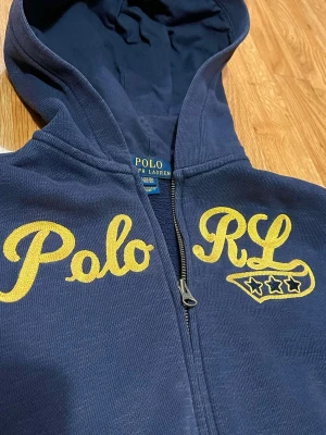 Polo RL Zip Hoodie - Säljer denna snygga vintage zip hoodien med fint broderat motiv 🤩Storlek L (14-16) kille, passar dig som är 155-165. Skicka ett meddelande vid minsta fråga😊