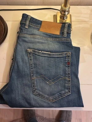 Blå Replay jeans med slitningar - Säljer ett par blå jeans från Replay i gott skick, storlek slim fit 32/32.  Pris kan diskuteras hur snabb affär!