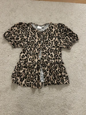 Leopardmönstrad topp ginatricot  - En kortärmad topp med knytningar i mitten.  Jätte fint skick och perfekt för skola/ vardags eller lite finare tillfällen. 