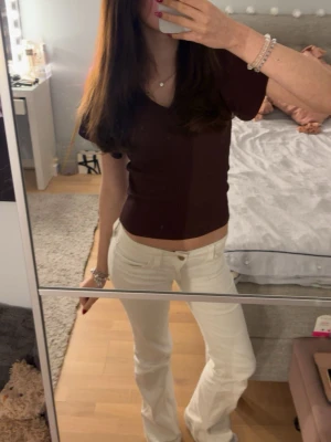 Vinröd ribbad topp med v-ringning - Säljer en brun ribbad topp från Only med v-ringning och korta, lite puffiga ärmar. Toppen har en croppad passform och är tillverkad i mjuk, stretchig bomullsblandning. (sista bilden är bara för att visa knytningen i ryggen, den är egentligen vinröd!!)