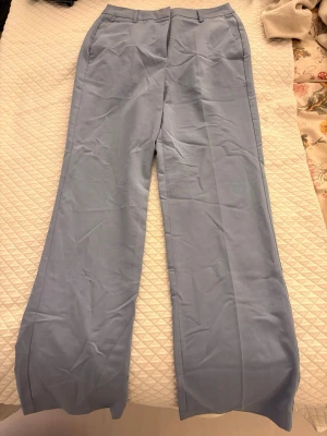 Ljusblå kostymbyxor med raka ben - Ett par högmidjade ljusblå kostymbyxor med raka ben från Vero Moda. Har sidofickor.