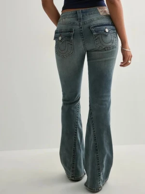 True Religion Joey Lowrise Flare Jeans - Säljer ett par blå True Religion Joey Lowrise Flare jeans med ikoniska bakfickor och kontrastsömmar. De har låg midja och utsvängda ben, klassisk knappstängning och detaljerade ficklock med silverknappar. Perfekta för dig som gillar retrovibbar och statement-jeans. Helt oanvända pga dem inte passa