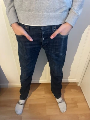 Lee Daren mörkblå jeans W30 L32 - Snygga mörkblå jeans från Lee, modell Daren. Klassisk femficksdesign med raka ben och normal passform. Jeansen har subtila slitningar och är tillverkade i slitstarkt bomullsmaterial. Perfekt för dig som gillar en enkel och stilren look.