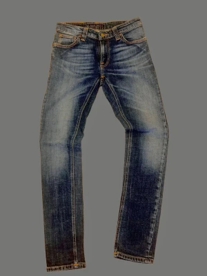 Nudie jeans 27/30 slim fit - Säljer dessa otroligt schyssta nudie jeans med mycket läcker fade. Jeansen är i perfekt skick (9,5/10)🔥. Jeansen är i storlek 27/30. Modellen är skinny lin vilket är en slim modell. Bara att skriva vid fler frågor.  Mått [CM] x2: Längd ≈ 94 Midja ≈ 33 Vad ≈ 14 Lår ≈ 21 ⚠️Mått kan variera med någon cm‼️ ⚠️Byxornas faktiska färg kan skilja sig från bilden.