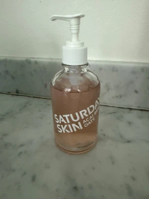 Saturday Skin Acai Berry + Oats Gel - Antioxidant gel cleanser från Saturday Skin med acai berry och havre. Kommer i en genomskinlig pumpflaska i glas på 150 ml med rosa geléliknande formula. Använt ett par pumpar , se bild. Inköpt denna vecka.