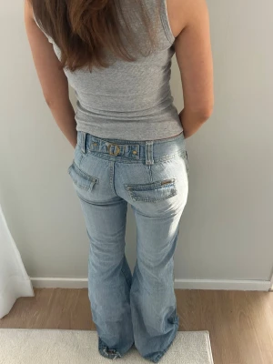 Ljusblå bootcut jeans  - Ljusblå lågmidjade jeans med coola bakfickor. Storlek XS. Midja: 36x2 cm innerben: 83 cm