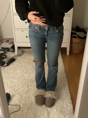 Blå bootcut jeans från Zara - Lågmidjade Jeans från Zara i bootcut form. midjemått: 34cm , innerbenslängd: 70cm💗De är ihopsydda mellan benen ( sista bilden ) men det är inget som syns vid användning. Pris kan diskuteras!