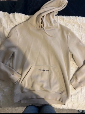 Beige Hoodie med tryck  - Stilren beige hoodie med snyggt tryck. Från H&M Re-tail second hand, i bra skick. Storlek S men passar även XS. Perfekt för vardag eller mysiga dagar hemma, bekväm och trendig!
