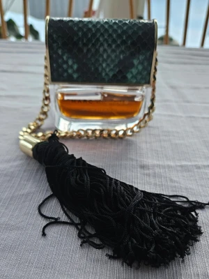 Marc Jacobs Decadence 50ml EdP -  Lite mer än 50% kvar Marc Jacobs Decadence Eau de Parfum i en unik flaska med guldkedja och grön detalj. Volym: 50 ml. Tillverkad i Spanien. Perfekt för dig som vill sticka ut med en ikonisk design på parfymhyllan.