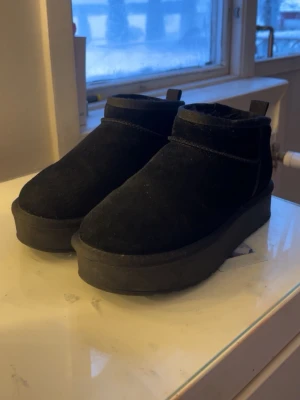 Svarta boots från Pace i mocka - Säljer ett par svarta boots från Pace i mjuk mocka med fluffigt foder på insidan. Skorna har en chunky platt sula och rund tå, perfekta för kalla dagar. Enkla att dra på med ögla bak och riktigt sköna att gå i. ny pris 800