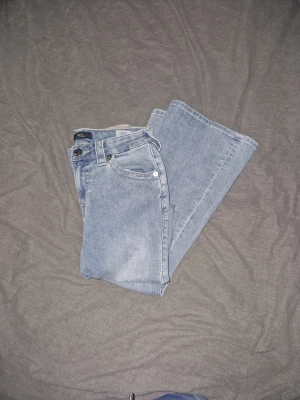 True Religion ljusblå jeans bootcut! - Säljer ett par ljusblåa True Religion jeans i storlek W26. Jeansen är aldrig använda, endast provade, då de tyvärr var för långa för mig., vilket gör att de sitter riktigt snyggt och trendigt.  I mycket fint skick, som nya. Perfekta om du vill ha äkta True Religion jeans till ett bra pris.