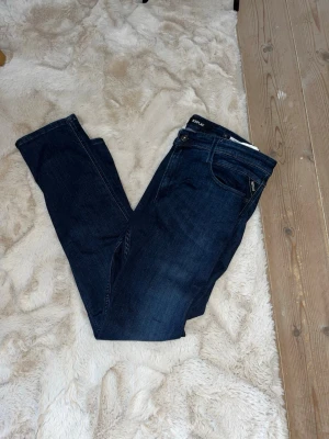 Replay Anbass mörkblå jeans - Säljer ett par knappt använda Replay Anbass jeans i mörkblå tvätt. Klassisk femficksmodell med snygga detaljer och diskret Replay-logga vid fickan. Jeansen har normal passform. W36 - L34