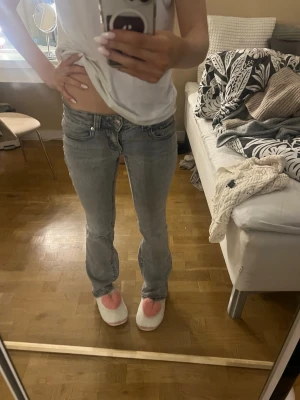 Grå bootcut jeans från Perfect Jeans - Säljer ett par grå jeans från Perfect Jeans i storlek 34. De har låg midja, bootcut-ben och klassiska  fickor. Jeansen är i stretchigt denim och har snygga slitningar för en avslappnad look.