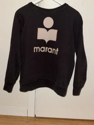 Isabel Marant Étoile sweatshirt – svart, ikonisk logga - Snygg och tidlös sweatshirt från Isabel Marant Étoile i klassiskt svart med det välkända logotrycket framtill. Perfekt för en avslappnad men stilren look – lika snygg till jeans som till kjol eller över klänning. Ett måste i garderoben för dig som gillar lyxig vardagsstil ✨