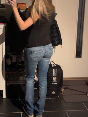 Lågmidjade blå jeans bootcut - Säljer ett par blå lågmidjade jeans med bootcut och dubbla knappar fram. Jeansen har klassiska fickor bak och fram. Använda ett fåtal gånger!💓Köpte dem nya för 900