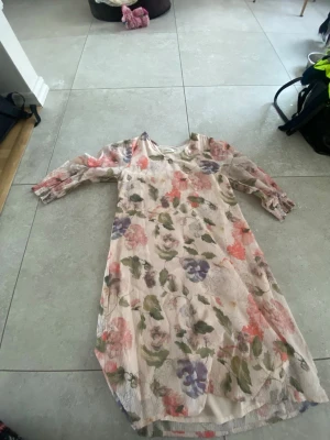 Blommig ljus klänning från Cream - Säljer en superfin ljus kortklänning från Cream i storlek 36. Klänningen har ett romantiskt blommigt mönster i rosa, lila, grön och beige, samt trekvartsärm med lätt puff och resår vid ärmslut. Perfekt för sommarens alla tillfällen!