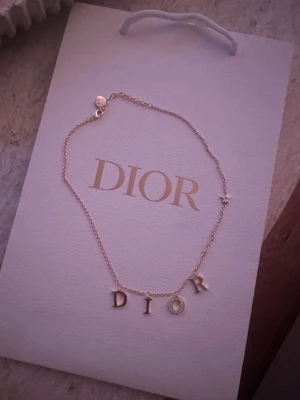 Dior halsband  - Bilderna visar ett halsband från Dior med bokstäverna D-I-O-R i guld nyskick 