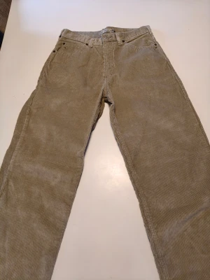 Beiga manchesterbyxor från P&B Desmazeres - Säljer ett par beiga manchesterbyxor från P&B Desmazeres. Byxorna har klassisk femficksdesign, raka ben och tydlig manchesterstruktur. Märkeslapp bak och snygga detaljer vid fickorna. Perfekta för dig som gillar retrostil och vill ha något unikt. Hittar ingen annan storlek än 38, men jag skulle kunna gissa utifrån min egen att det är en W30-31. Hör gärna av er med frågor!