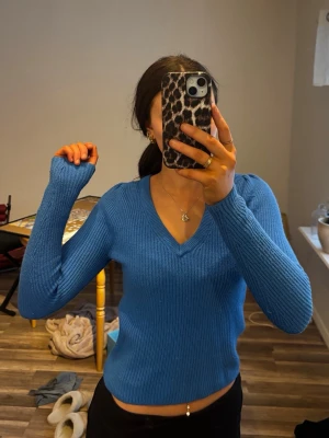 Blå ribbad stickad tröja V-ringad - Snygg blå stickad tröja med ribbad struktur och V-ringad hals.  Jätte skön att bära. Sitter som s men är xs