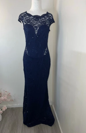 Klänning - Elegant marinblå långklänning med spets och paljettdetaljer. Figurnära passform och dragkedja baktill. Storlek 36 (S) men passar även mig som vanligtvis bär XS. Använd en gång och i utmärkt skick 💙