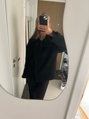 Svart rock med bred krage - Svart ull kappa ifrån arket! Super fin och i bra skick utåt. Fickorna har dock gjort sitt och har hål som ni ser på bilderna men annars är de inget fel på jackan! 