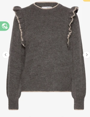 Grå stickad tröja med volang från Selected Femme - Mysig grå stickad tröja från Selected med volangdetaljer längs axlarna och kontrastkant i beige. Rund halsringning och långa ärmar. Perfekt för lager-på-lager och chill höst- och vinterstil. Bra material och kvalité, lite finare. Super snygg!! Nypris 899 kr.