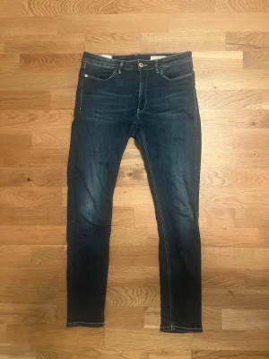 Dondup - Snygga blå jeans från Dondup, tillverkade i Italien. klassisk femficksdesign. Jeansen har en mörk tvätt och är gjorda i stretchigt denim för en bekväm passform. Perfekt för dig som gillar stilrena och moderna jeans. Storlek W29 L29. Dessa är helt nya använda 1 gång